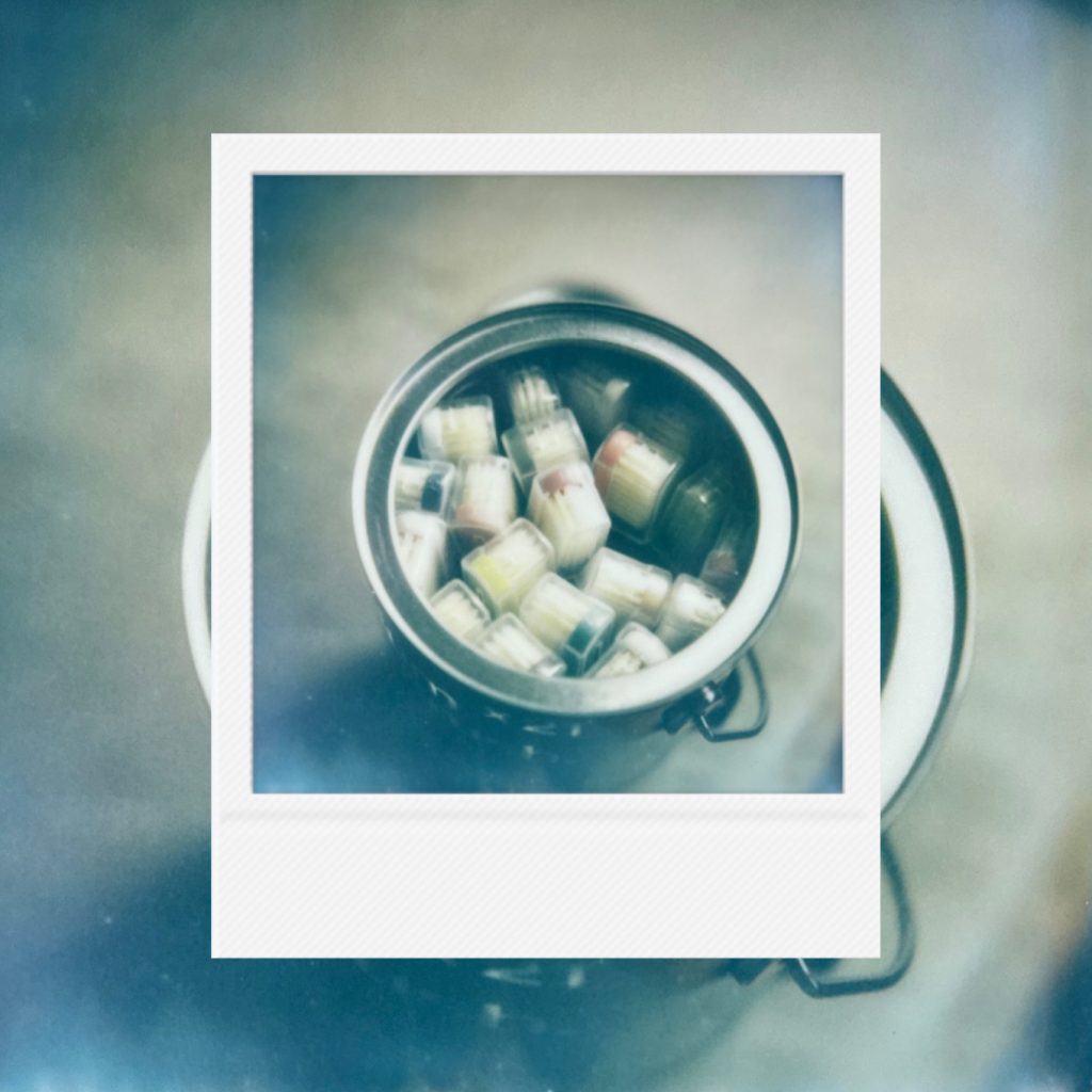 The delicate texture of toothbrush bristles packed in a small tin capturing a simple and neat record of daily life within faded analog film tones