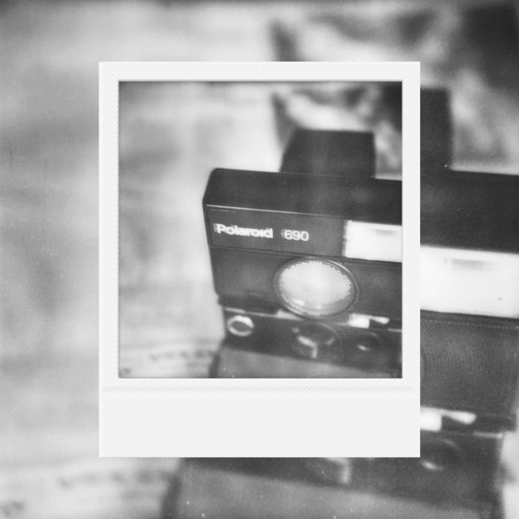A record of analog contemplation layered within a Polaroid frame featuring the gaze of a vintage camera projected in coarse monochrome textures