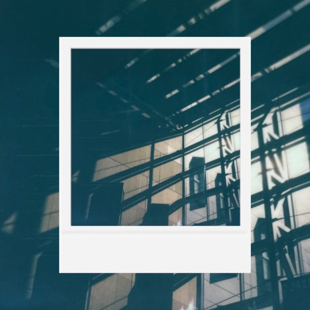 Dazzling noon fragments flowing along cold glass walls capturing geometric trajectories of light within an analog film frame