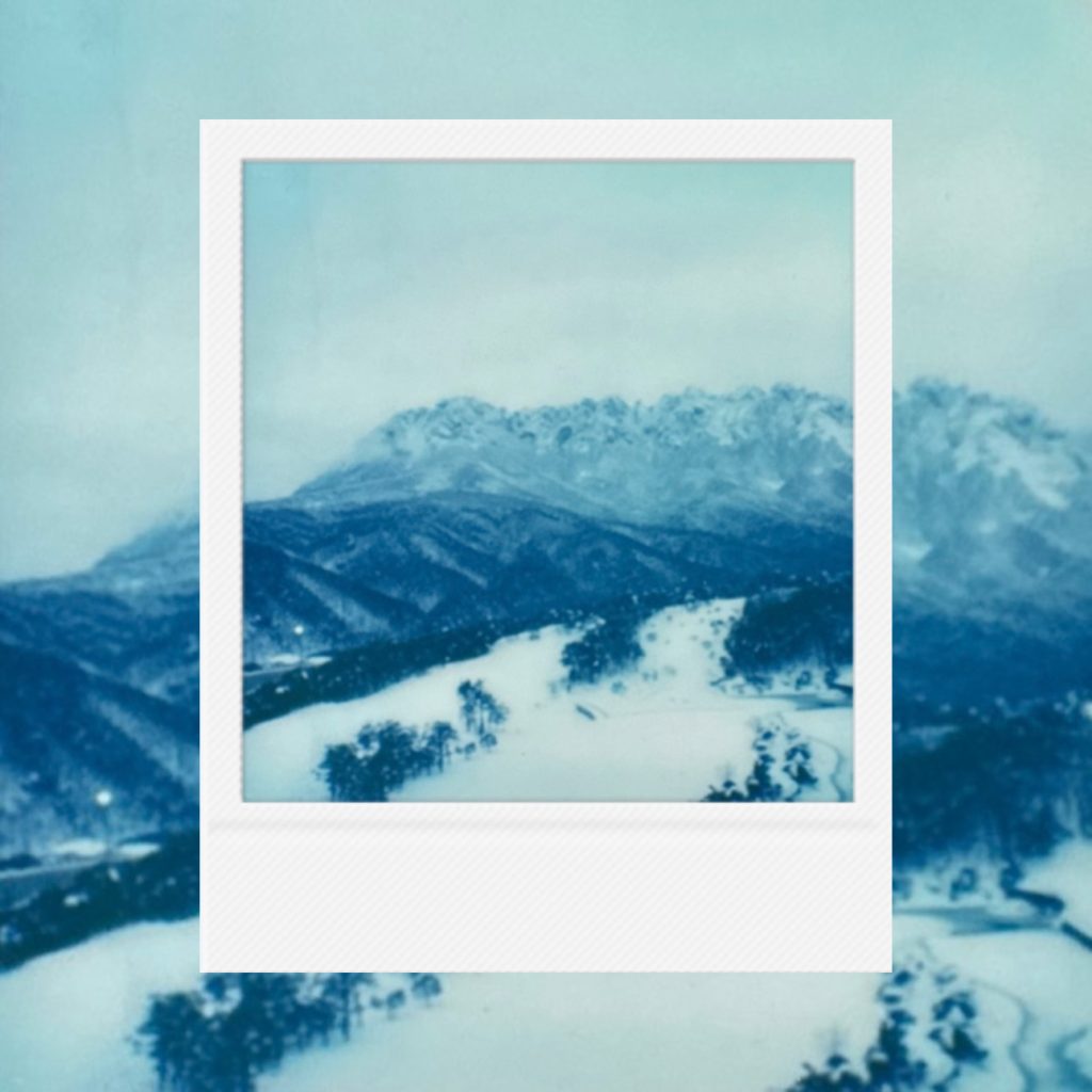 The quiet and chilly breath of the earth flowing along snow ridges, capturing the peak of blue winter within an analog film frame