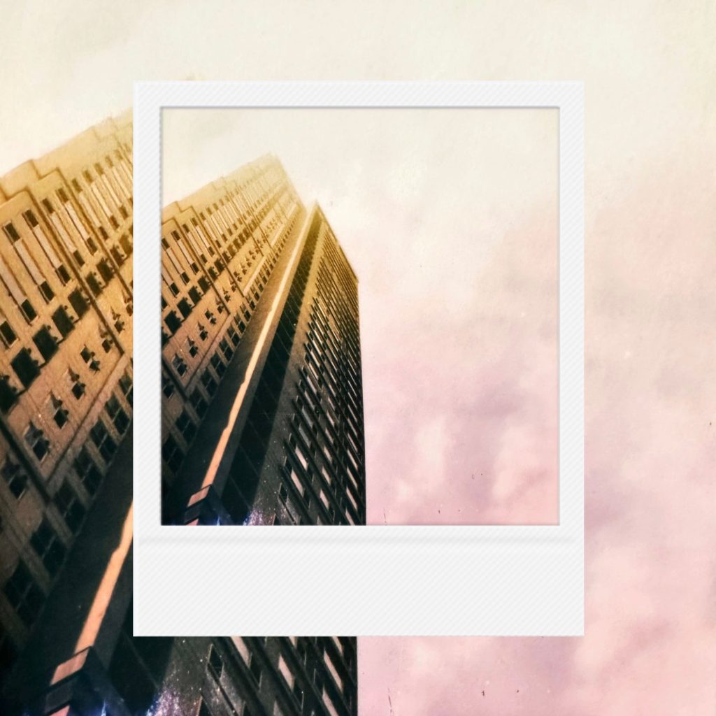 The vertical aesthetics of a city layered within coarse analog film textures featuring soft sunlight seeping through urban spires