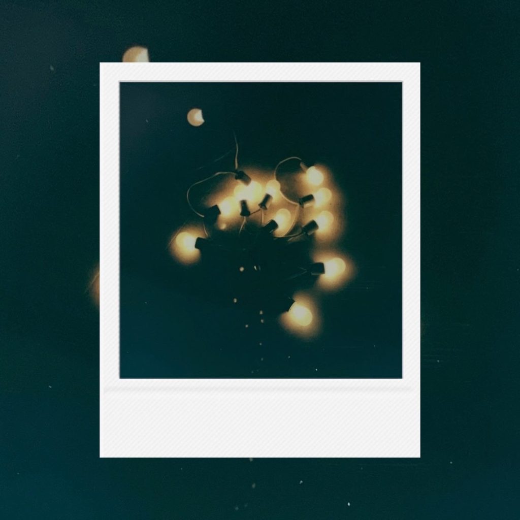 The soft scattering of orange lights within deep stillness capturing a record of tender comfort within an analog film frame