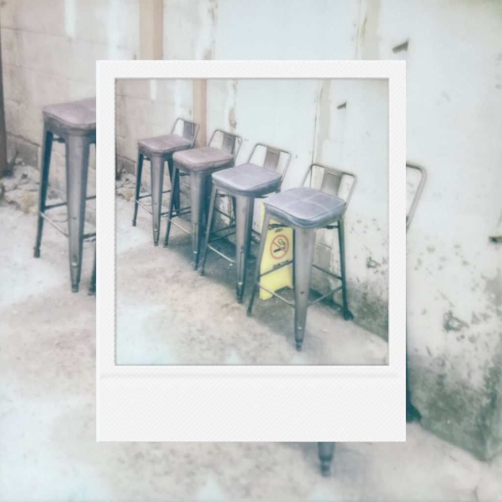 A quiet row of empty chairs holding the traces of passing conversations, the stillness between arrivals, and the gentle anticipation of moments yet to unfold.