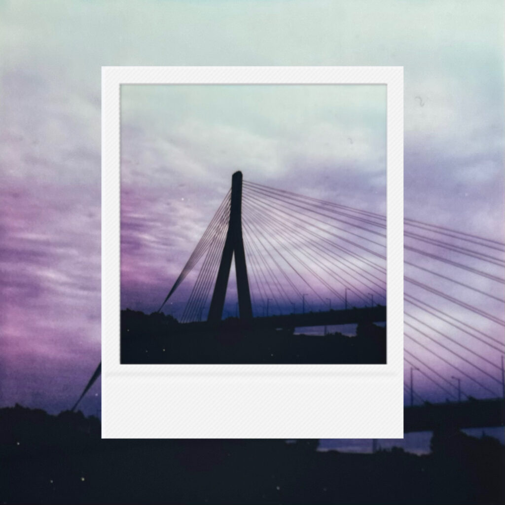 Violet dusk settling softly across the quiet bridge and fading sky.